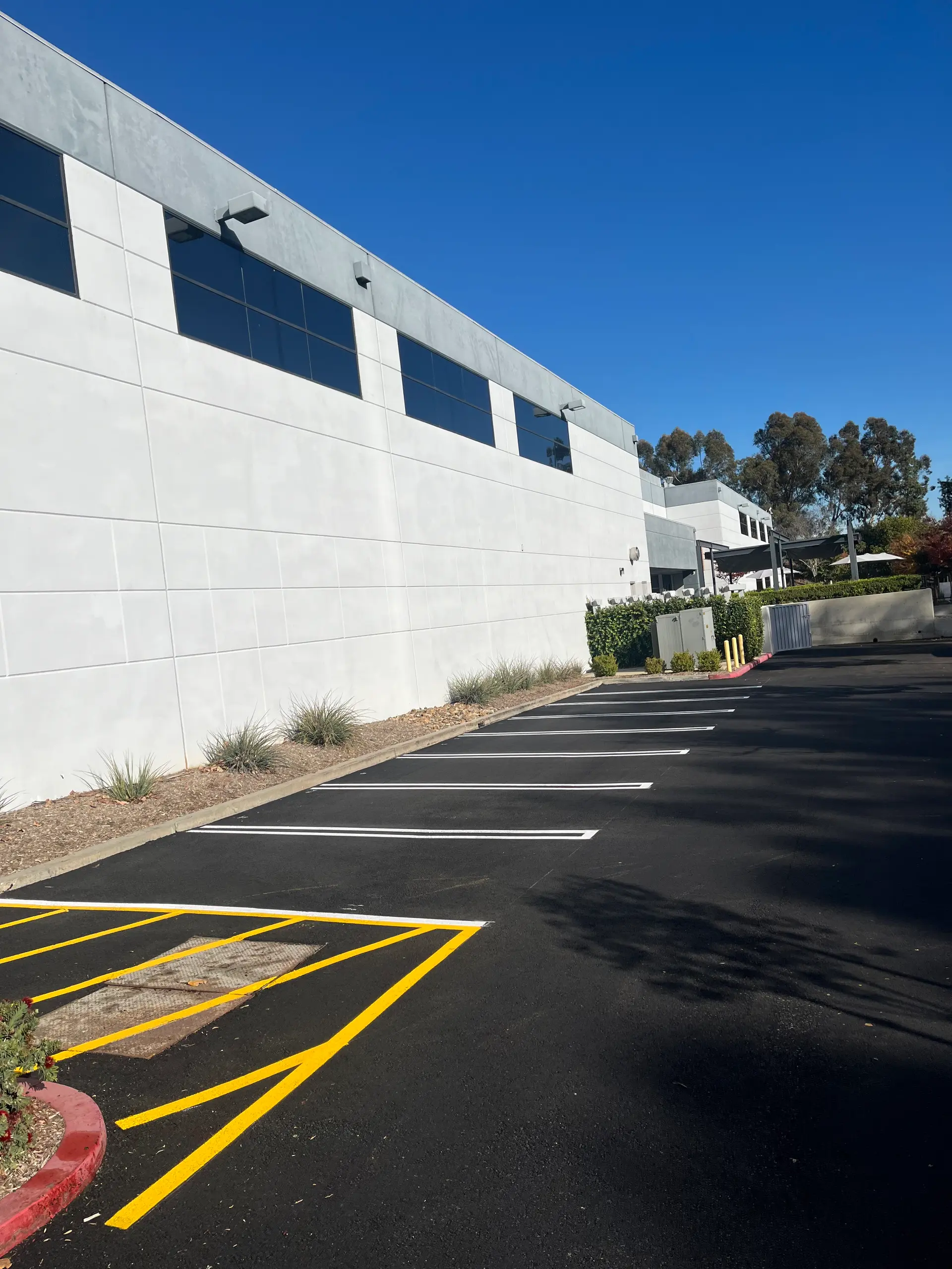 Crisp new parking stall striping on dark asphalt by Native Union Engineering